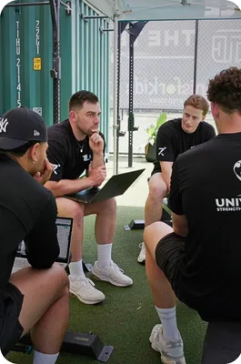 Home | Resilience Rehab & Performance 26 Group discussing in outdoor gym setting.