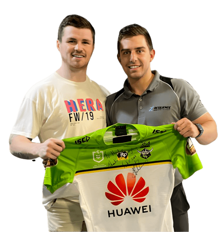 Two individuals holding a signed jersey.